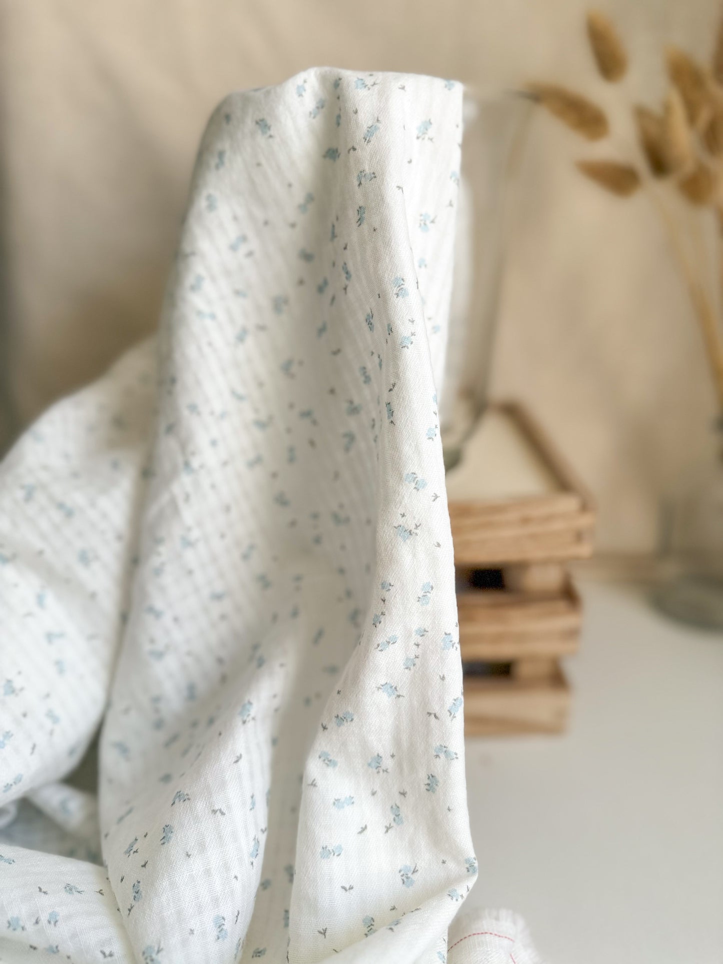 Organic cotton fabric with tiny pale blue floral print on a white backround