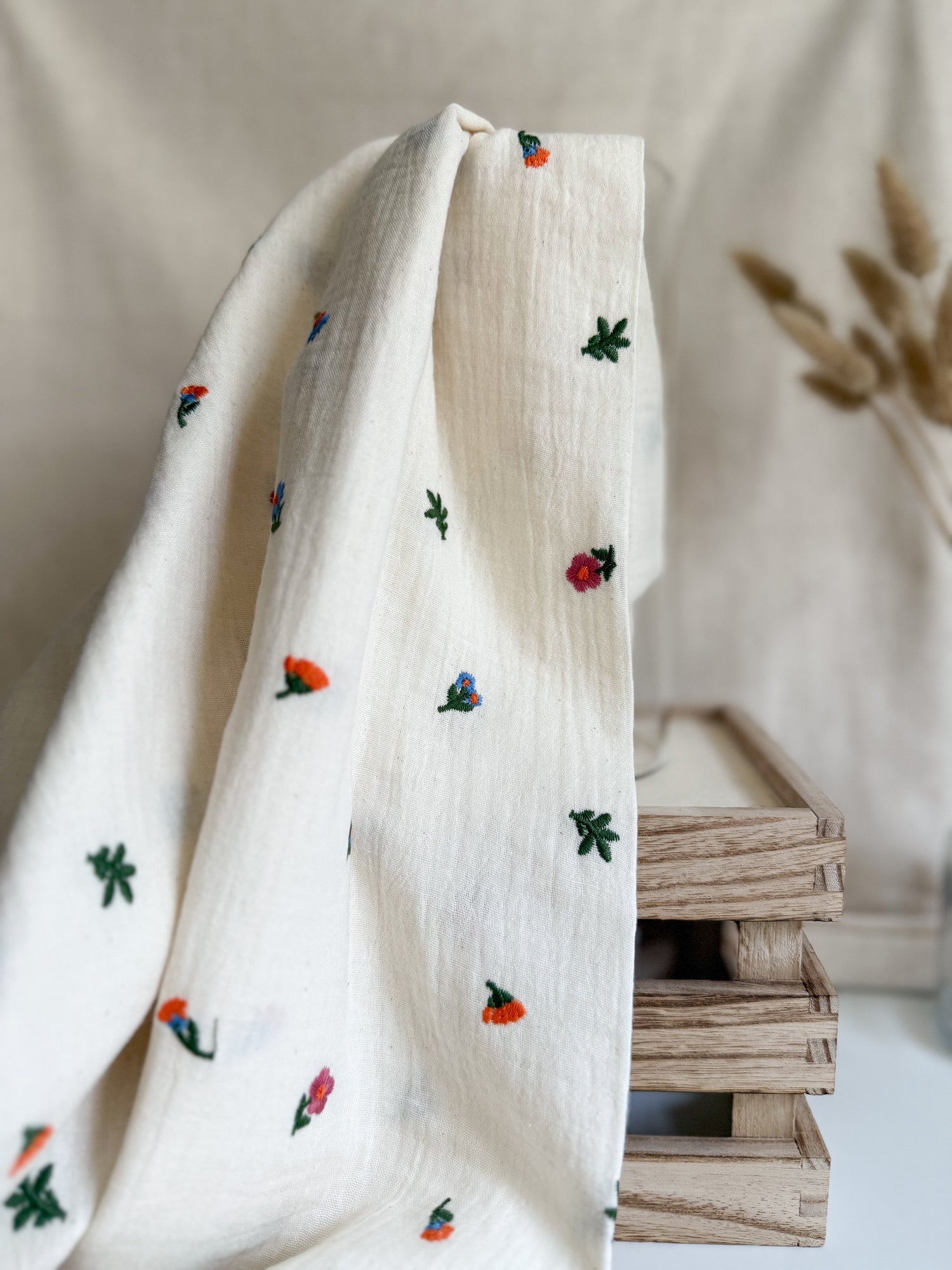 A natural coloured cotton double gauze with bright embroidered floral pattern. 