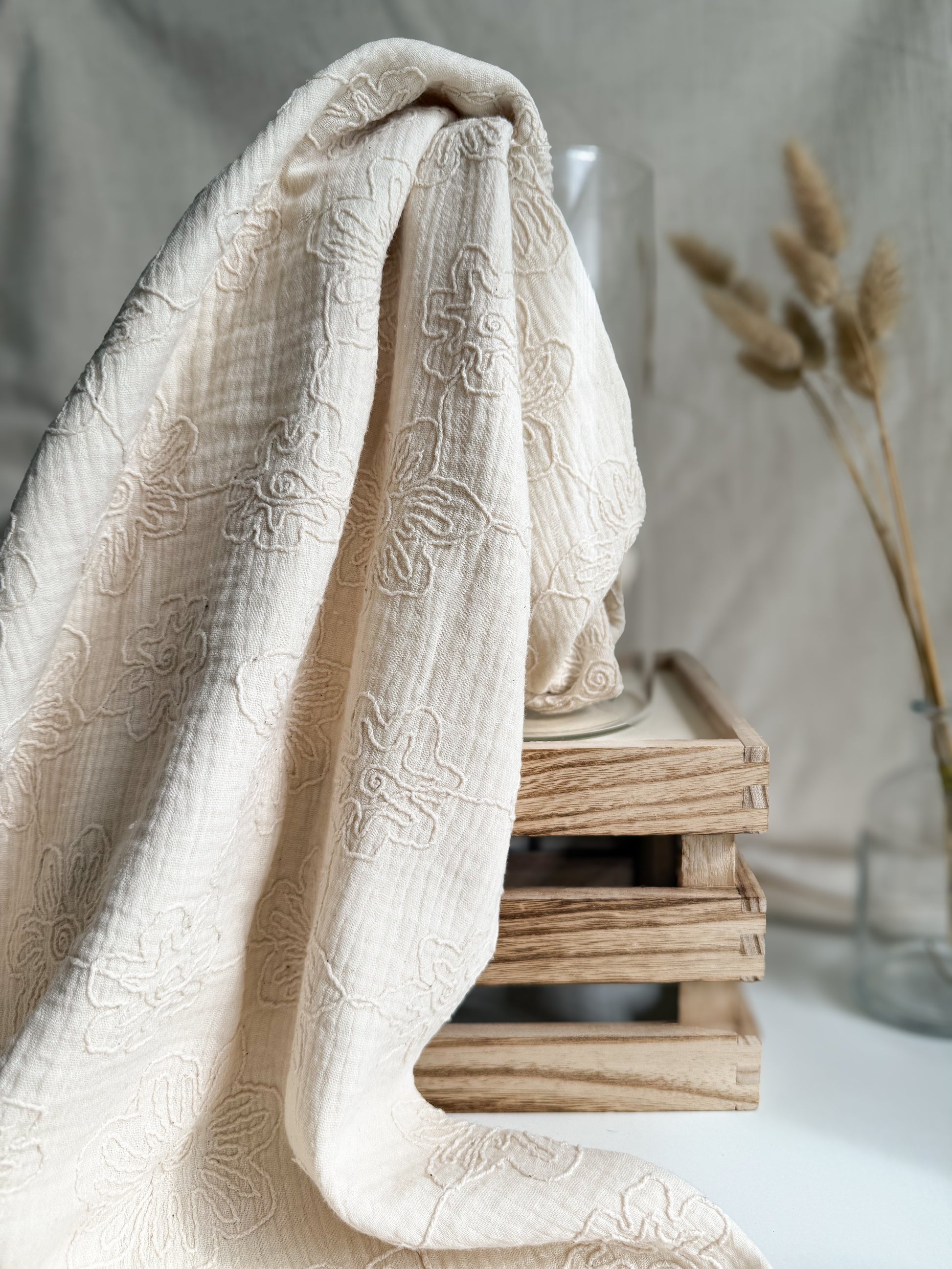 An embroidered natural coloured double gauze fabric with a delicate neutral flower pattern. 