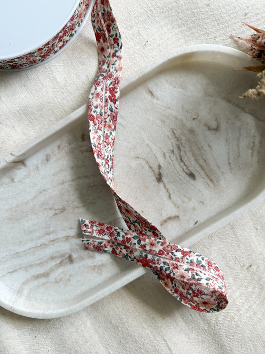 An organic pink ditsy floral folded bias binding which is 20mm wide. 