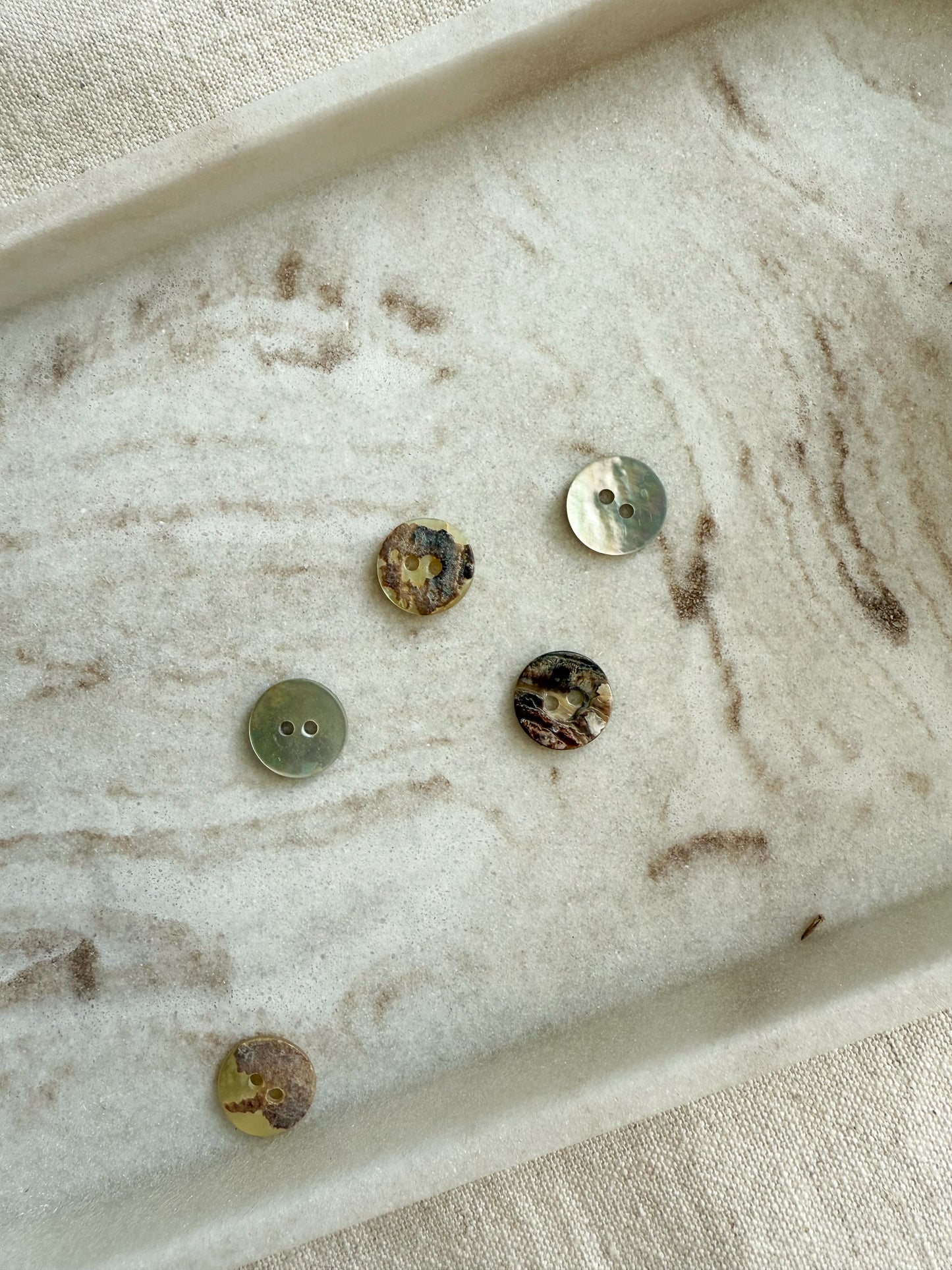 11mm, 13mm, 15mm mother of pearl button with two holes. Displaying the natural finish on the face and back side. 